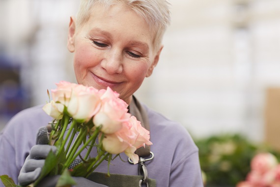 woman smelling a bouquet of roses and smiling