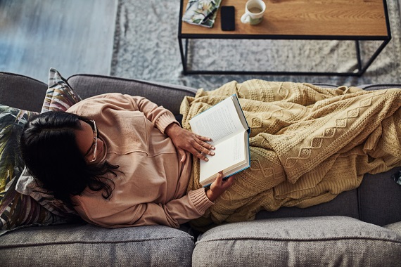 woman reading a book on a sofa