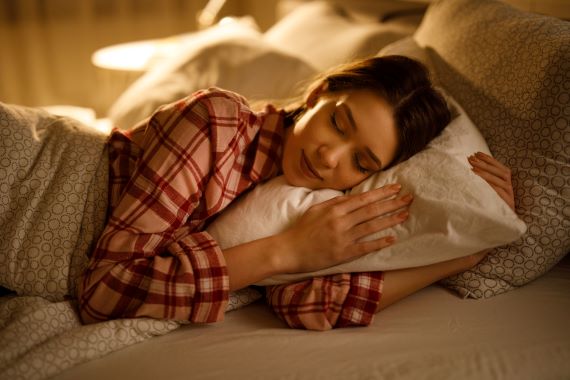 woman asleep in bed resting her head on a pillow