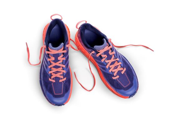 overhead view of a pair of blue sneakers with orange laces