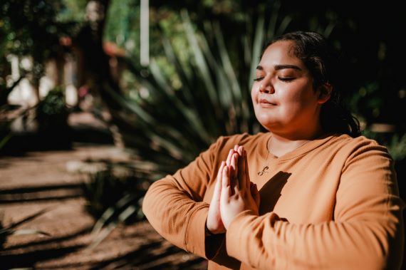 photo of a woman in prayer or meditation while sitting outdoors