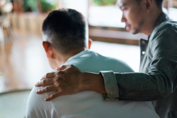 man with his arm around a loved one's shoulders