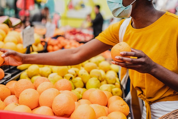 woman looking at fruit at the farmers market