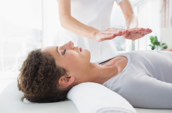 woman lying on a table during a healing touch session