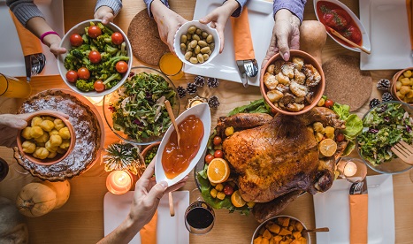 Holiday meal featuring turkey, vegetables, salad, and bread.