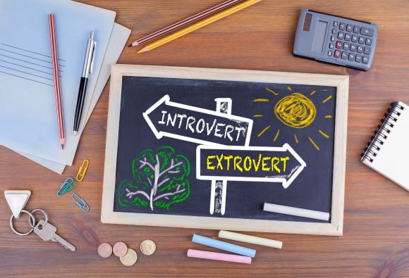 chalk board with introvert and extrovert drawn on a sign with arrows pointing in either direction