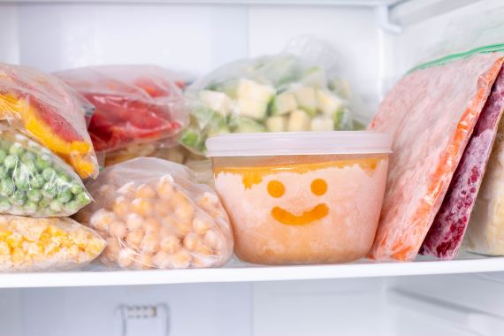 stacks of frozen veggies and soups in freezer bags in the freezer