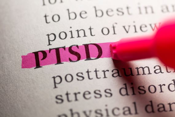 PTSD written in a book and highlighted in hot pink