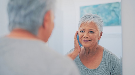 woman smiling at herself in the mirror