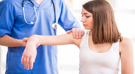 Doctor checking for broken bones in the arm.