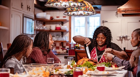 Family carving the turkey at their Thanksgiving Dinner.